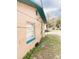 Side view of the peach-colored home with blue trim on a grassy lot at 5076 Fairport Ave, De Leon Springs, FL 32130