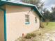 Side view of the home with brick, two windows, and lawn at 5076 Fairport Ave, De Leon Springs, FL 32130