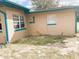 Rear of home with windows and a sandy, partially grass-covered lot at 5076 Fairport Ave, De Leon Springs, FL 32130
