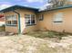 Back of the peach-colored home with blue trim on a sandy lot at 5076 Fairport Ave, De Leon Springs, FL 32130