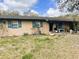 Inviting exterior showcasing light brick, blue shutters, and landscaping, creating a warm curb appeal at 5076 Fairport Ave, De Leon Springs, FL 32130