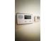 Smart thermostat and conventional thermostat mounted on the wall at 5076 Fairport Ave, De Leon Springs, FL 32130