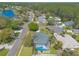 Overhead shot of a quiet community with manicured lawns, mature trees, and a screened-in pool at 6 Greenvale Dr, Ormond Beach, FL 32174