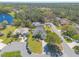 Aerial view of the home in its neighborhood, featuring a lake, mature trees, and landscaping, all under a sunny sky at 6 Greenvale Dr, Ormond Beach, FL 32174