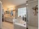 Stylish bathroom featuring double sinks, corner tub, glass shower, and decorative accents at 6 Greenvale Dr, Ormond Beach, FL 32174