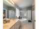 Well-lit bathroom with double vanity, corner tub, glass enclosed shower, and decorative tile at 6 Greenvale Dr, Ormond Beach, FL 32174