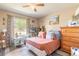 Cozy bedroom featuring hardwood floors, natural light from the window, and a comfortable bed with decorative pillows at 6 Greenvale Dr, Ormond Beach, FL 32174