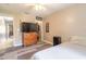 Cozy bedroom with wood floors, ceiling fan and chest of drawers with a large TV on top at 6 Greenvale Dr, Ormond Beach, FL 32174