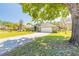 Charming green home with a spacious lawn and a brick-paved driveway leading to a two-car garage, beautifully shaded by mature trees at 6 Greenvale Dr, Ormond Beach, FL 32174
