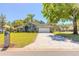 Charming green home with a well-manicured lawn, mature trees, and a brick-paved driveway leading to a two-car garage at 6 Greenvale Dr, Ormond Beach, FL 32174