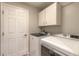 Functional laundry room featuring a washer, dryer, storage cabinets, and a door for easy access at 6 Greenvale Dr, Ormond Beach, FL 32174