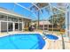 Stunning screened-in pool area with lush landscaping, ideal for outdoor entertaining and relaxation at 6 Greenvale Dr, Ormond Beach, FL 32174
