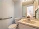 Well-lit bathroom featuring a toilet, sink, vanity with marble countertops, and accessibility grab bar at 60 N Halifax Dr # 1050, Ormond Beach, FL 32176