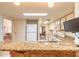 Open kitchen featuring stone countertops and views of the living and dining areas at 60 N Halifax Dr # 1050, Ormond Beach, FL 32176