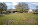 Expansive green yard with a single-story brick home and covered parking area at 600 Tabatha Dr, Osteen, FL 32764