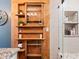 Well-organized bathroom with natural wood shelves, cabinets, shower niche and glass door at 617 S Flamingo Dr, Holly Hill, FL 32117