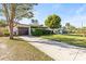 Lovely single-story home with a lush green lawn, large tree, and paved driveway at 617 S Flamingo Dr, Holly Hill, FL 32117