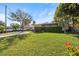 Well-manicured front lawn and lush privacy hedge enhance the curb appeal of this residence at 617 S Flamingo Dr, Holly Hill, FL 32117