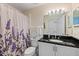 Cozy bathroom featuring a white sink, black countertop and patterned wall paper at 6408 Whit Ct, Port Orange, FL 32128