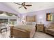 Spacious bedroom featuring a wooden bed frame, ceiling fan, and pool view at 6408 Whit Ct, Port Orange, FL 32128