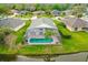 Aerial view of a screened-in pool, lush landscaping, and water view at 6408 Whit Ct, Port Orange, FL 32128