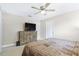 Spacious bedroom features comfortable bed, ceiling fan, natural light and a dresser with TV at 815 Charles Ave, Orange City, FL 32763