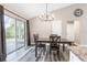Bright dining room features modern light fixture, gray wood floors and sliding glass door to backyard at 815 Charles Ave, Orange City, FL 32763