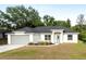 Charming single-story home with a well-maintained lawn, gray door and two-car garage at 815 Charles Ave, Orange City, FL 32763