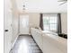 Bright living room featuring hardwood floors, white door, and a comfortable white leather couch at 815 Charles Ave, Orange City, FL 32763