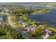 This overhead view shows the house with neighboring houses along the street and the beautiful lake in the background at 902 Cloverleaf Blvd, Deltona, FL 32725