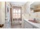 Bathroom with a vanity, pink sink, wallpaper and tiled floors at 902 Cloverleaf Blvd, Deltona, FL 32725