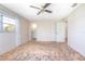 A bedroom with a window, ceiling fan, ensuite bathroom and closet doors at 902 Cloverleaf Blvd, Deltona, FL 32725
