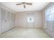 A bedroom with a window, a closet with folding doors, beige walls and carpet at 902 Cloverleaf Blvd, Deltona, FL 32725