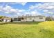 The property boasts a large, green lawn and a partially screened-in patio, ideal for outdoor activities and relaxation at 902 Cloverleaf Blvd, Deltona, FL 32725