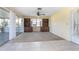 Spacious living room featuring neutral carpet, shelving units and ceiling fan, plus sliding glass door access to patio at 902 Cloverleaf Blvd, Deltona, FL 32725