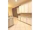 Kitchen with white cabinets, stainless steel appliances, tile floors, and granite countertops at 1812 Leather Fern Dr, Ocoee, FL 34761