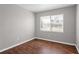 Bright, neutral bedroom features gleaming hardwood floors and a large window allowing natural light at 1020 Alladin Dr, Deltona, FL 32725