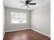 This cozy bedroom features hardwood floors, a ceiling fan, and plenty of natural light from the window at 1020 Alladin Dr, Deltona, FL 32725