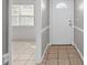 Entryway with ceramic tile, white door with sidelights, and natural light at 1020 Alladin Dr, Deltona, FL 32725