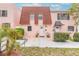 Charming pink townhome featuring a unique red-tiled roof and well-maintained front yard landscaping at 108 Mitchell Pl # 108, Daytona Beach, FL 32118
