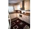 This is a kitchen with white cabinetry, an oven, a window, and a multicolored rug at 108 Mitchell Pl # 108, Daytona Beach, FL 32118