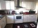 Bright kitchen with white cabinets, appliances, and a stylish range hood at 108 Mitchell Pl # 108, Daytona Beach, FL 32118
