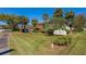 Indigo Woods Condominium community sign surrounded by lush landscaping and mature palm trees at 112 Lacosta Ln # 115, Daytona Beach, FL 32114