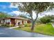 Well-maintained exterior view with lush landscaping and mature trees at 112 Lacosta Ln # 115, Daytona Beach, FL 32114