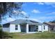Back exterior view of home featuring a covered patio and solar panels at 1162 Prescott Blvd, Deltona, FL 32738