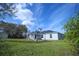 Exterior view of home featuring a backyard with a gazebo, solar panels and mature trees at 1162 Prescott Blvd, Deltona, FL 32738