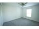 Clean, carpeted bedroom featuring a ceiling fan, window, and closet space at 1162 Prescott Blvd, Deltona, FL 32738