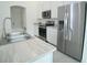 Open kitchen with marble countertops, stainless steel appliances and stainless steel refrigerator at 1162 Prescott Blvd, Deltona, FL 32738