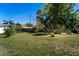 Expansive backyard featuring a well-maintained lawn, mature trees, and a chicken coop at 1199 Galgano Ave, Deltona, FL 32725