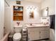 Bright bathroom featuring white cabinets, a pink sink, decorative mirror, and a bathtub at 1199 Galgano Ave, Deltona, FL 32725